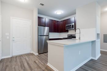 A kitchen with a white counter and a stainless steel refrigerator.